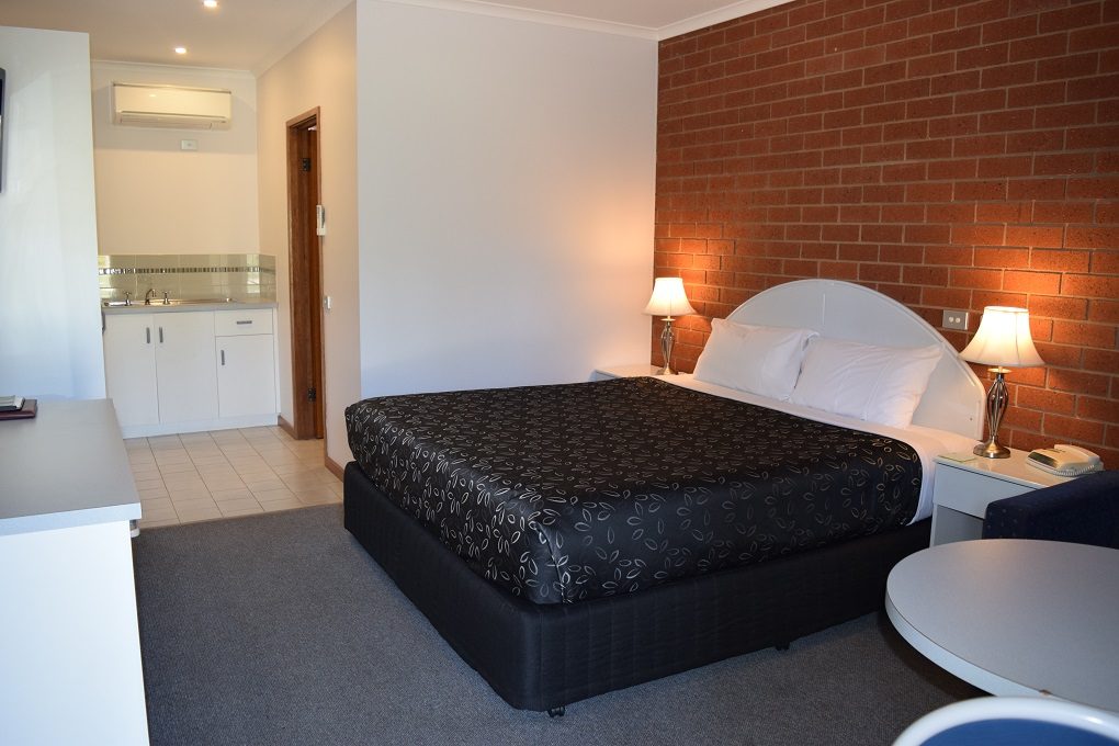Executive Suite with king bed and brick feature wall