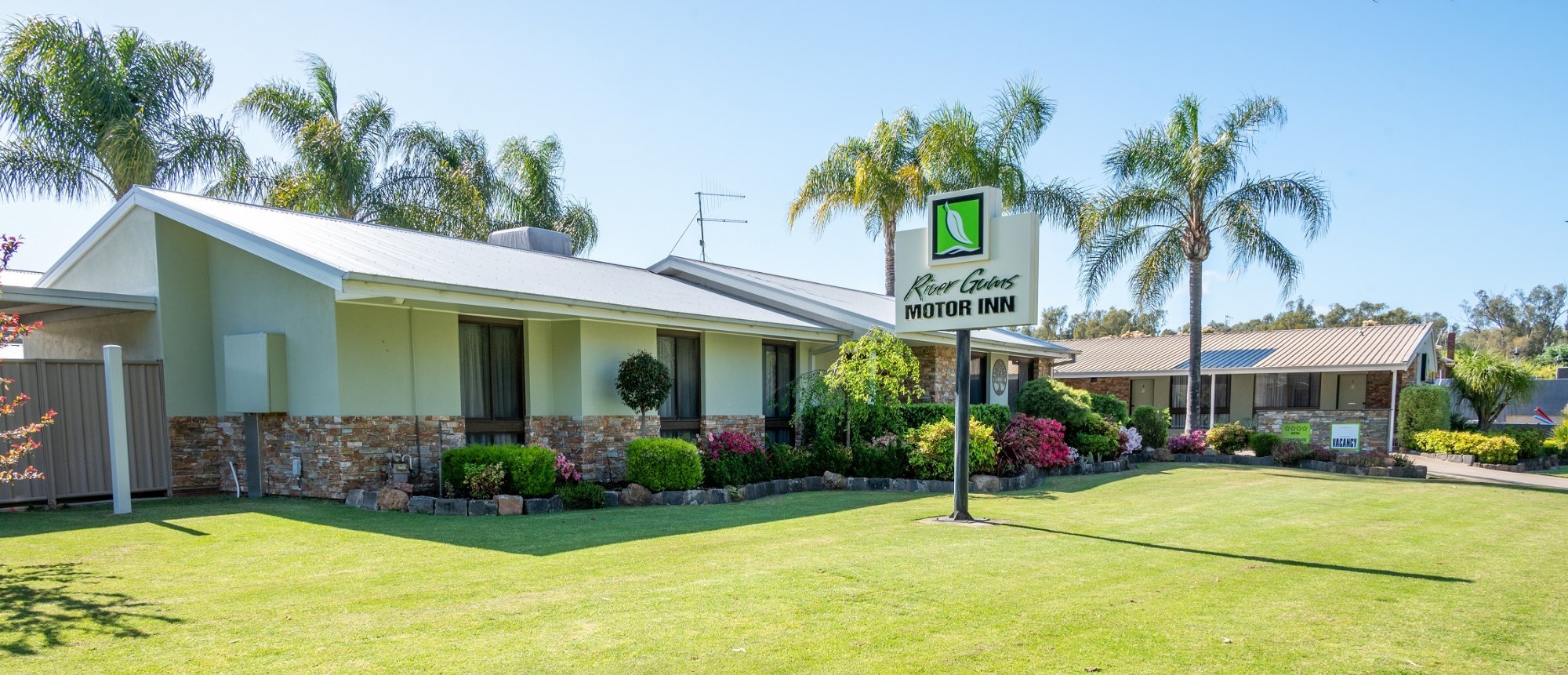 River Gums Motor Inn, Barooga, surrounded by palms and landscaped gardens on Golf Course Road